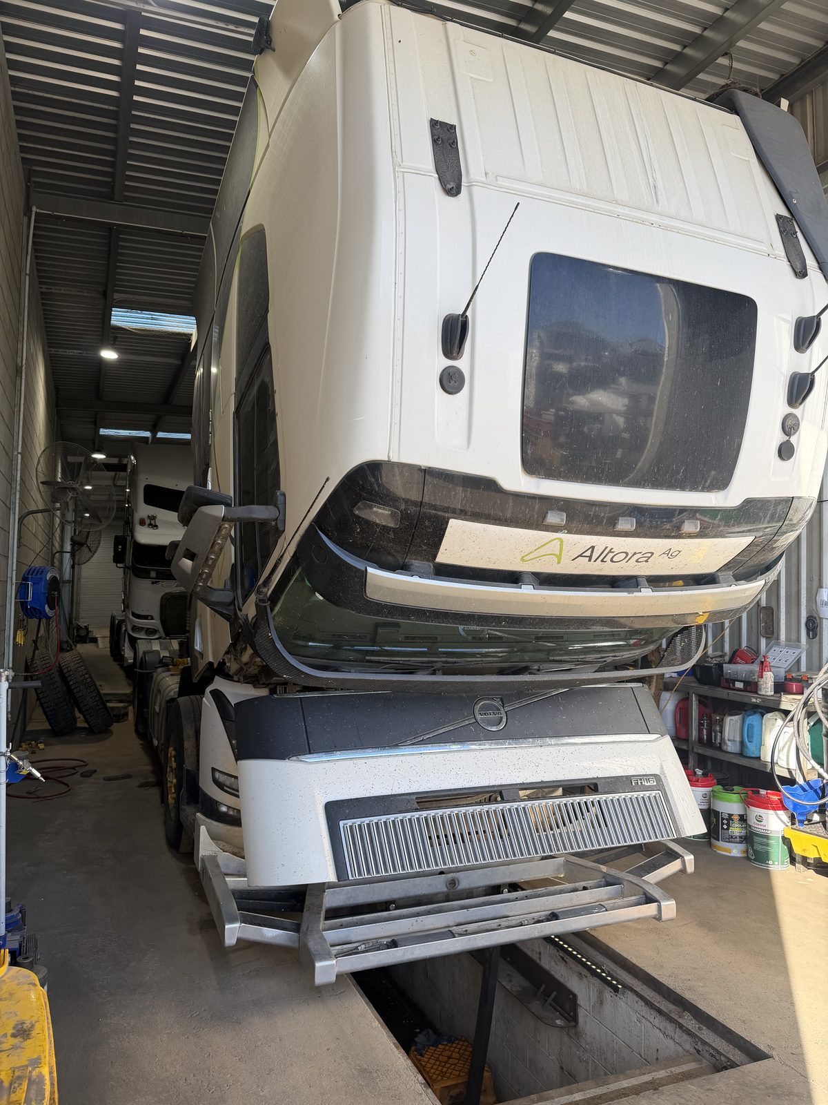 Volvo FH16 with the cab tilted over the pit in the JSM workshop
